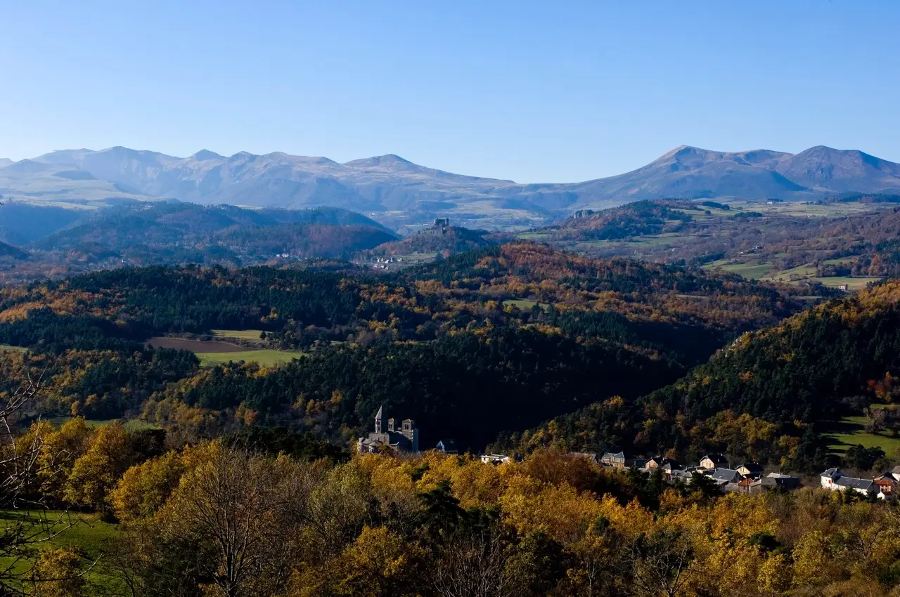 Paysage d'Auvergne en automne : forêts, village et monts volcaniques
