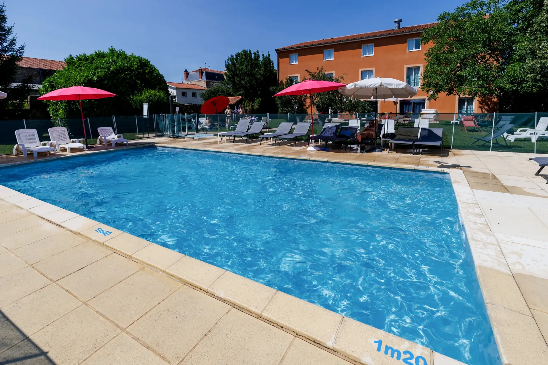 Piscine chauffée de l’Hôtel Le Pariou à Issoire avec transats et parasols